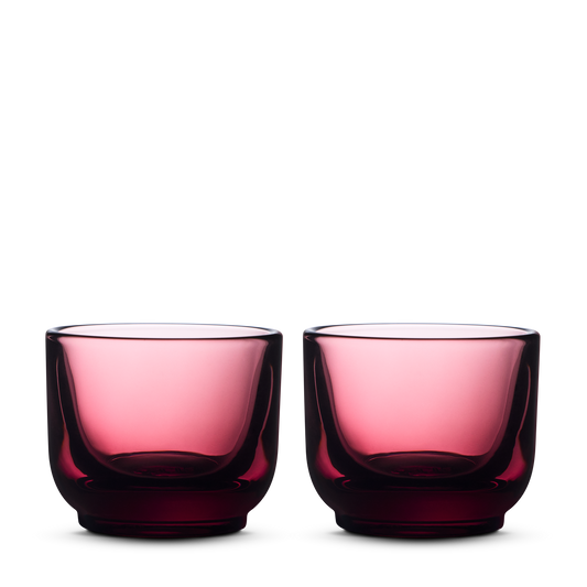 Two round Fellow Pirch Espresso Glasses in garnet on a plain white background.