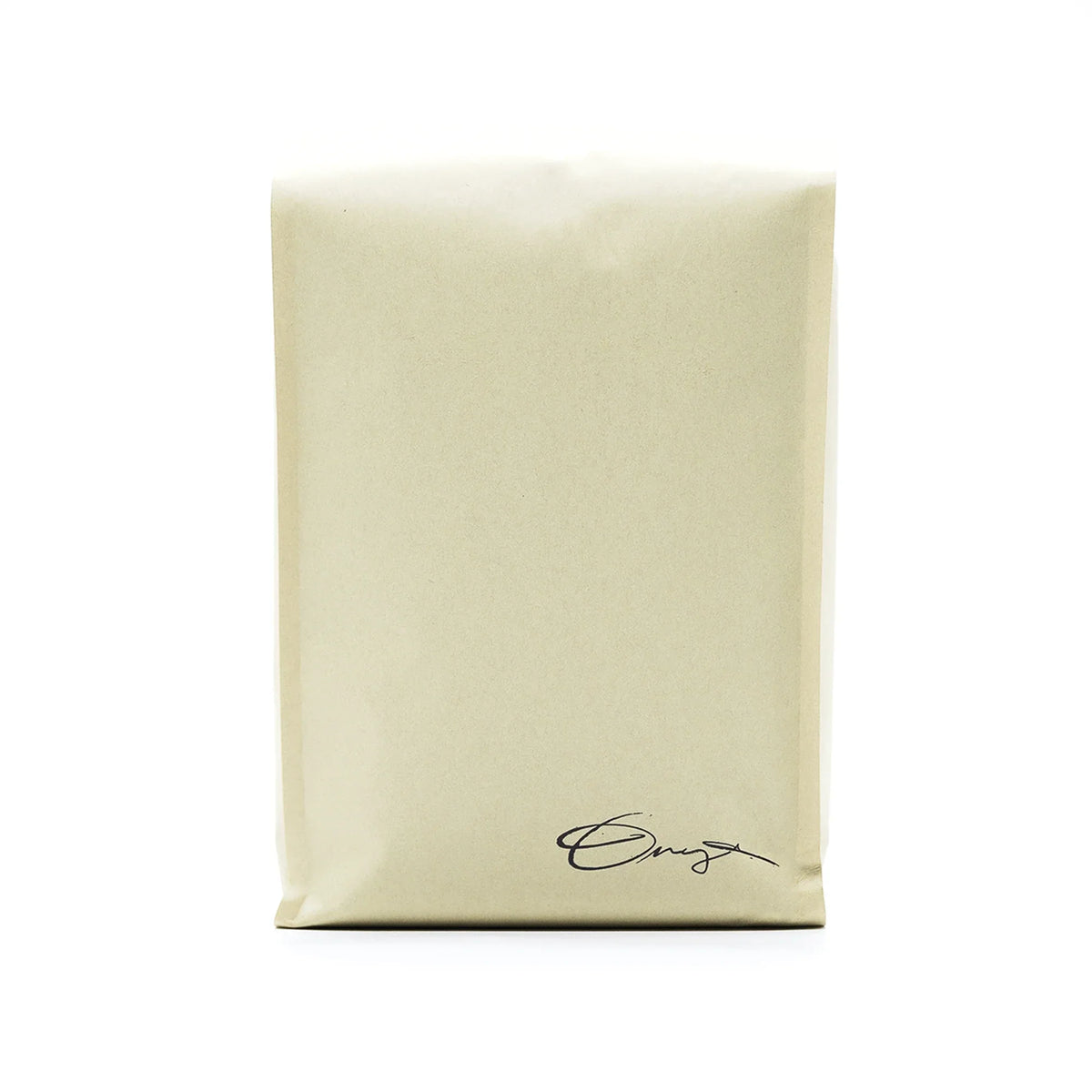 A beige Monarch bag by Onyx Coffee Lab with a small cursive logo and dark chocolate coffee notes.